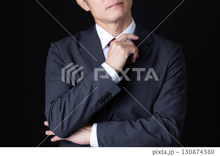 考え事をするスーツを着たミドル男性ビジネスマン 130874380