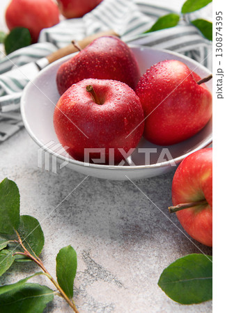 Fresh red apples resting in bowl on marble countertop 130874395