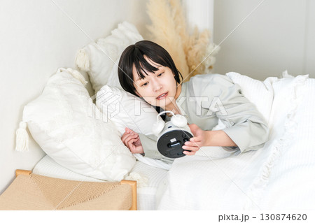 目覚まし時計を見て驚くびっくりする若いアジア人女性(寝坊,遅刻,寝過ごす) 目覚まし時計を見て驚くびっくりする若いアジア人女性(寝坊,遅刻,寝過ごす) 130874620