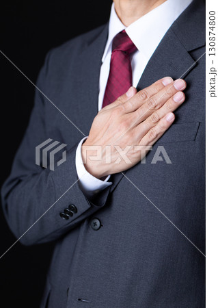 胸に手を当てるスーツを着たミドル男性ビジネスマン 130874800