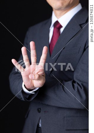 指を4本立てるスーツを着たミドル男性ビジネスマン 130874811