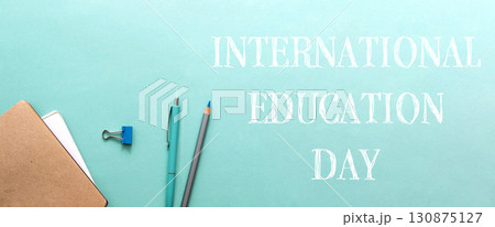 International education day. A blue background with a pencil and pen on it. International education day. A blue background with a pencil and pen on it. 130875127