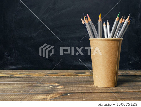 Wooden table with a brown cup of pencils on it Wooden table with a brown cup of pencils on it 130875129
