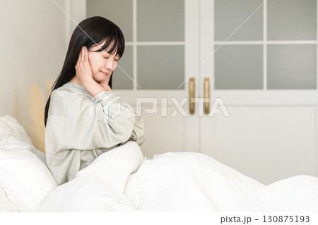 ベッドで睡眠中に騒音で耳を塞ぐ若いアジア人女性(騒音トラブル,安眠妨害,睡眠障害) ベッドで睡眠中に騒音で耳を塞ぐ若いアジア人女性(騒音トラブル,安眠妨害,睡眠障害) 130875193