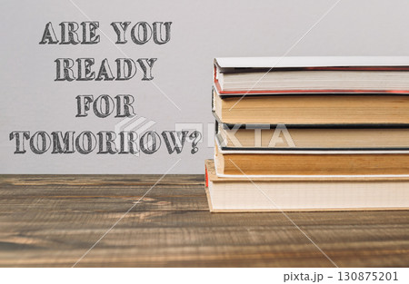 A stack of books with the words Are you ready for tomorrow written on top A stack of books with the words Are you ready for tomorrow written on top 130875201