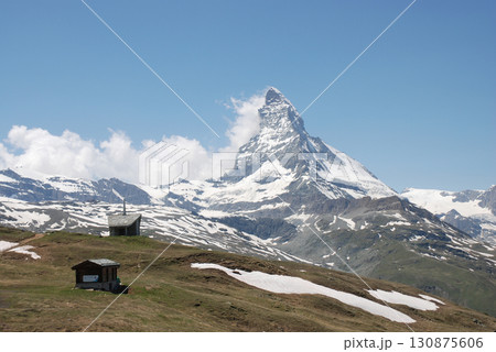 草原を行くトレッキングコースから眺める盛夏のマッターホルンの勇壮なパノラマビュー 130875606