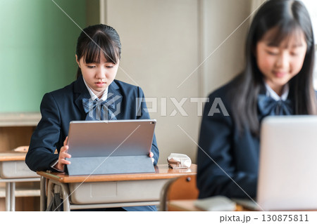 パソコン,タブレットを使って勉強する制服姿の中学生・高校生の女子生徒 パソコン,タブレットを使って勉強する制服姿の中学生・高校生の女子生徒 130875811