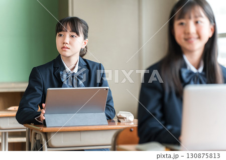 パソコン,タブレットを使って勉強する制服姿の中学生・高校生の女子生徒 パソコン,タブレットを使って勉強する制服姿の中学生・高校生の女子生徒 130875813