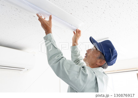 ライトの取付け工事をするシニア男性作業員 130876917