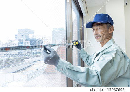 メジャーで測定する内装工事業者 130876924