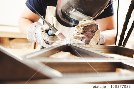 Male in face mask welds with argon-arc welding Male in face mask welds with argon-arc welding 130877088