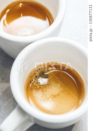 Close-up of Two White Espresso Cups With Rich Crema Served on Countertop, Top View 130877131