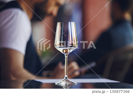 White wine glass at the table on summer terrace of restaurant background. Blind tasting concept. White wine glass at the table on summer terrace of restaurant background. Blind tasting concept. 130877166