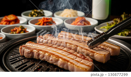 Fresh Korean Pork Belly Grilling on Hot Plate with Side Dishes 130877299
