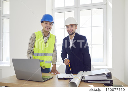 Portrait Of Happy Builder And Businessman Client Planning Office Renovation Portrait Of Happy Builder And Businessman Client Planning Office Renovation 130877360