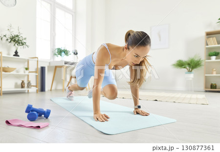 Woman Performing Abs Exercises During Home Fitness Training Woman Performing Abs Exercises During Home Fitness Training 130877361