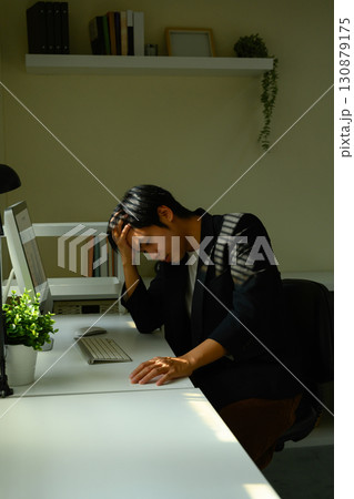 Tired office worker experiencing frustration and mental fatigue during busy workday 130879175