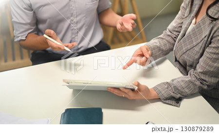 Business professionals discussing ideas while using tablet device during office meeting 130879289