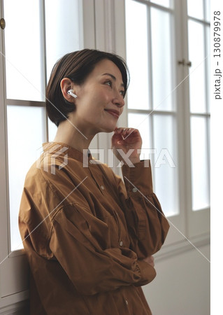窓際で音楽やラジオを聴いている女性 窓際で音楽やラジオを聴いている女性 130879978