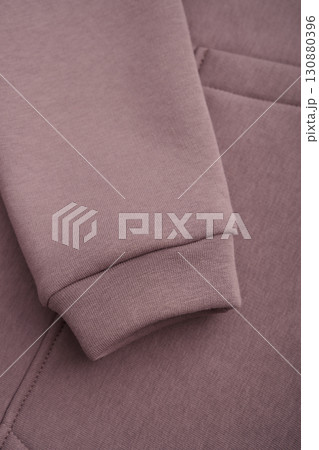 Sweatshirt texture. Close-up of the sleeve of a light brown sweatshirt. Cotton. Warm textile fabric, macro photography. 130880396