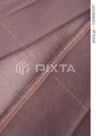 Brown textile with seam. Inner loop seam of clothing. Mocha cotton. Clothing with insulation on fleece. Brown textile with seam. Inner loop seam of clothing. Mocha cotton. Clothing with insulation on fleece. 130880397