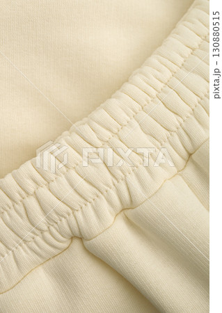 Warm tracksuit in a soft yellow color. Close-up of the elastic waistband of the pants. Cotton. Warm tracksuit in a soft yellow color. Close-up of the elastic waistband of the pants. Cotton. 130880515