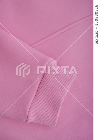 Texture of a hoodie. Close-up of the sleeve of a pink hoodie. Warm textile fabric, macro. Texture of a hoodie. Close-up of the sleeve of a pink hoodie. Warm textile fabric, macro. 130880516