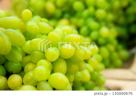 A bunch of white grapes lies on the counter in a vegetable store 130880676
