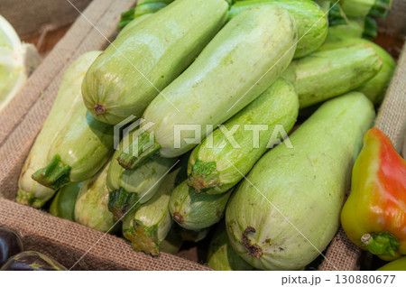 Fresh vegetables sold at an open market stall. Zucchini stacked in a pyramid, close-up of the counter in the store 130880677