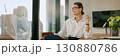 A confident businesswoman standing proudly in a modern office, showcasing her professionalism 130880786