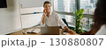 A professional woman confidently working in a modern office environment and setting 130880807
