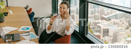A dedicated businesswoman collaborating effectively with colleagues in a modern office A dedicated businesswoman collaborating effectively with colleagues in a modern office 130880816