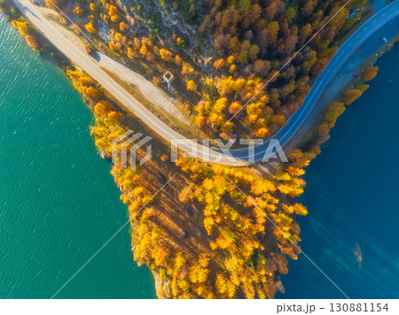 Winding road along the lake. Road through the forest. Drone view of a road with cars.  130881154