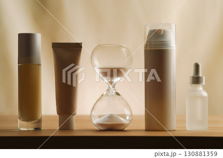 A modern still life featuring skincare products with an hourglass, embodying timeless beauty and minimalism. Focus on creativity and elegance in self-care displayed on a serene, muted neutral backdrop 130881359