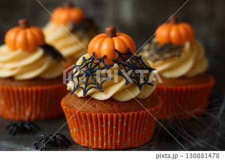 Halloween-themed cupcakes with orange frosting, pumpkin decorations, and spider web designs Halloween-themed cupcakes with orange frosting, pumpkin decorations, and spider web designs 130881478