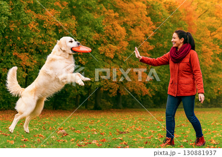 フリスビーで遊ぶ女性と犬 130881937