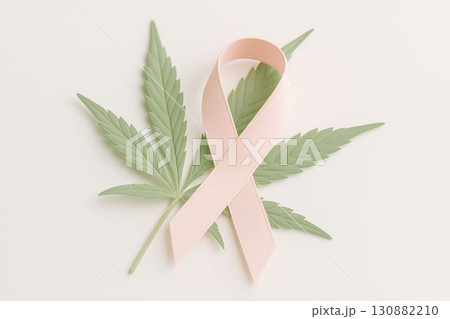 Pink awareness ribbon placed on green cannabis leaves, symbolizing health, wellness, and support for cancer awareness, promoting a message of hope and healing in a serene setting Pink awareness ribbon placed on green cannabis leaves, symbolizing health, wellness, and support for cancer awareness, promoting a message of hope and healing in a serene setting 130882210