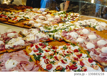 assorted pizza al taglio in an italian pizza shop 130883216