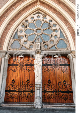 Ornate wooden church doors with intricate carvings and decorative stained glass elements Ornate wooden church doors with intricate carvings and decorative stained glass elements 130883568