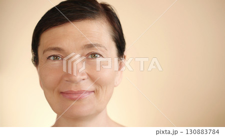 Middle aged mature happy Caucasian woman 50s with wet hair, looking at camera, smiling, isolated background, close up portrait. Advertisement for anti-aging whitening, skin care. Copy space. Middle aged mature happy Caucasian woman 50s with wet hair, looking at camera, smiling, isolated background, close up portrait. Advertisement for anti-aging whitening, skin care. Copy space. 130883784