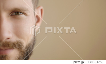 Extreme close-up, headshot half face of a confident young man 30s. Advertisement of skin care, facial care products for men. Isolation background, slow motion, copy space. Extreme close-up, headshot half face of a confident young man 30s. Advertisement of skin care, facial care products for men. Isolation background, slow motion, copy space. 130883785