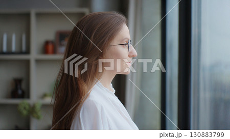 Close-up portrait of young beautiful business woman with brunette hair. Self-confident lady, good looking female executive with glasses on office background. Concept of a new idea Side view Copy Space 130883799
