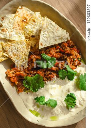 Bowl with cream dip, minced topping and tortilla 130883897