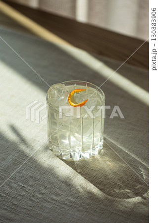 Gin and tonic cocktail with ice in faceted glass Gin and tonic cocktail with ice in faceted glass 130883906
