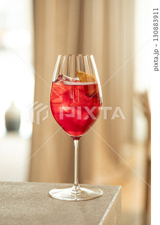 Red cocktail with orange and ice in wine glass 130883911