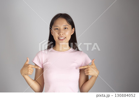 Girl is smiling and pointing to herself with both hands, indicating me or myself Girl is smiling and pointing to herself with both hands, indicating me or myself 130884052