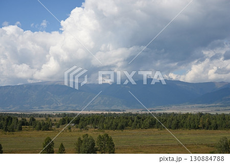 Floating cumulus clouds over the valley and mountains 130884788
