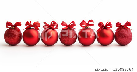 Row of red Christmas baubles with bows on white 130885364