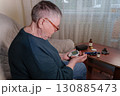 an older adult woman utilizing a handheld glucometer to test her blood sugar levels from the comfort of her own home 130885473