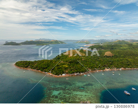 Coastline with boats over turquoise sea water. Blue sky and clouds. Coron, Palawan. Philippines. 130886978